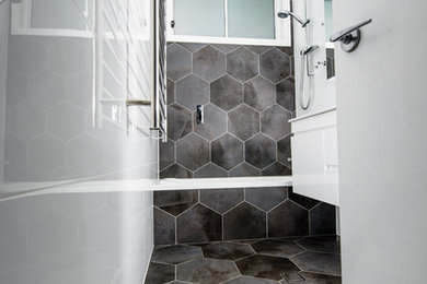 Small modern 3/4 bathroom in Sydney with flat-panel cabinets, white cabinets, an alcove tub, a shower/bathtub combo, gray tile, porcelain tile, white walls, porcelain floors and an integrated sink.