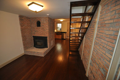 Example of a small classic open concept dark wood floor living room design in Baltimore with white walls, a corner fireplace and a brick fireplace