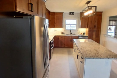 Inspiration for a timeless vinyl floor and gray floor eat-in kitchen remodel in Other with an undermount sink, shaker cabinets, medium tone wood cabinets, granite countertops, white backsplash, subway tile backsplash, stainless steel appliances, an island and multicolored countertops