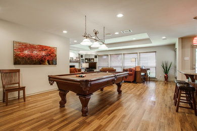 Design ideas for a large traditional open concept family room in Dallas with a game room, white walls and medium hardwood floors.