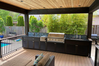 Inspiration for a modern outdoor kitchen deck remodel in Portland with a roof extension