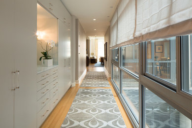 Photo of a large contemporary hallway in New York with beige walls, light hardwood floors and brown floor.