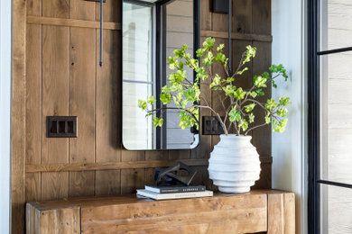 Entryway - rustic medium tone wood floor, brown floor and exposed beam entryway idea in Boise with beige walls and a black front door