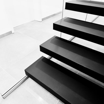 Kragarmtreppe in matt schwarz mit Weißglas