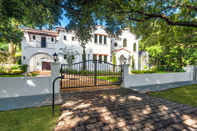 Large mediterranean white two-story stucco house exterior idea in Tampa with a hip roof and a tile roof
