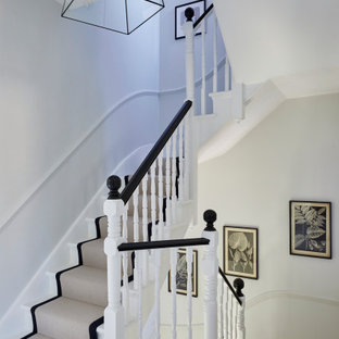 Photo of a medium sized traditional painted wood curved wood railing staircase in London with painted wood risers.