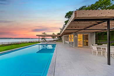 Inspiration for a mid-sized modern backyard stone and rectangular pool house remodel in New York
