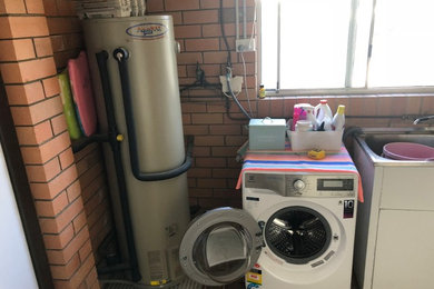 Multifunktionaler, Mittelgroßer Moderner Hauswirtschaftsraum mit Waschbecken, grauer Wandfarbe, Porzellan-Bodenfliesen und grauem Boden in Brisbane