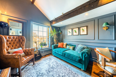 ロンドンにある高級な小さなエクレクティックスタイルのおしゃれな書斎 (青い壁、無垢フローリング、造り付け机、茶色い床、表し梁、パネル壁) の写真
