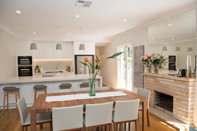 Contemporary open plan kitchen in Sydney with medium hardwood floors and with island.
