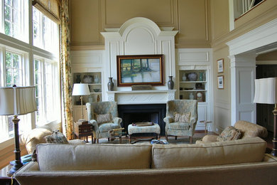 Mid-sized elegant formal and enclosed medium tone wood floor and brown floor living room photo in Charleston with beige walls, a standard fireplace, a wood fireplace surround and no tv