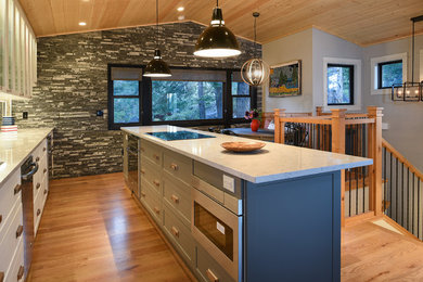 Mid-sized transitional single-wall light wood floor eat-in kitchen photo in Phoenix with an undermount sink, shaker cabinets, white cabinets, quartz countertops, blue backsplash, ceramic backsplash, stainless steel appliances and an island