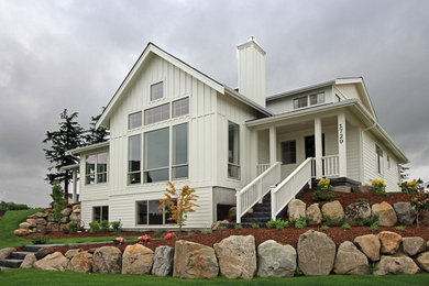 Photo of a large country three-storey white exterior in Seattle with concrete fiberboard siding and a gable roof.