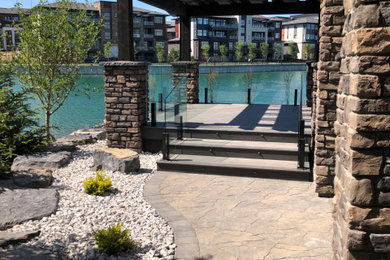 Huge mountain style side yard brick patio kitchen photo in Calgary with a gazebo