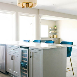 Photo of a medium sized classic walk-out basement in Omaha with beige walls, light hardwood flooring, a ribbon fireplace, a plastered fireplace surround and beige floors.