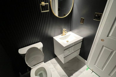 Inspiration for a small modern black tile white floor powder room remodel in New York with a bidet and a floating vanity