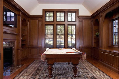 Inspiration for a large timeless enclosed dark wood floor game room remodel in Boston with white walls, a standard fireplace, a stone fireplace and a wall-mounted tv