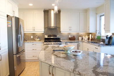Eat-in kitchen - mid-sized traditional u-shaped ceramic tile eat-in kitchen idea in Calgary with an undermount sink, raised-panel cabinets, white cabinets, quartz countertops, metallic backsplash, glass tile backsplash, stainless steel appliances and an island