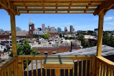 Photo of a mid-sized contemporary rooftop deck in Baltimore with a pergola.