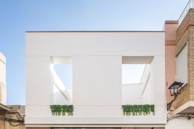 Imagen de fachada de casa blanca moderna de tamaño medio de dos plantas con revestimiento de metal