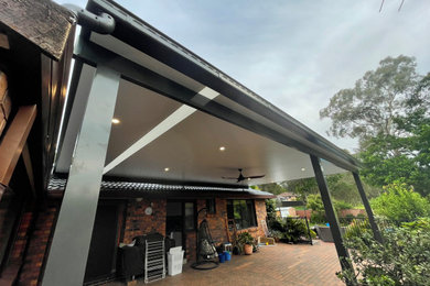 Inspiration for a large modern backyard patio in Sydney with a pergola.