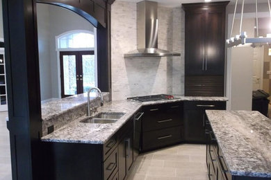 Inspiration for a mid-sized contemporary u-shaped limestone floor open concept kitchen remodel in Cleveland with a double-bowl sink, shaker cabinets, dark wood cabinets, stainless steel appliances, an island and gray backsplash