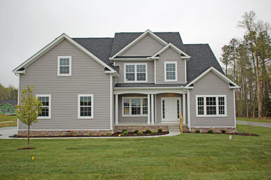 Example of a large farmhouse gray two-story vinyl exterior home design in Other