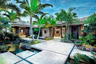 This is an example of a mid-sized tropical front yard shaded garden in Hawaii with with pond and concrete pavers.