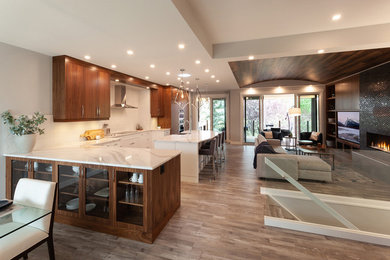 Design ideas for a large transitional single-wall open plan kitchen in Calgary with a farmhouse sink, flat-panel cabinets, medium wood cabinets, quartzite benchtops, white splashback, porcelain splashback, stainless steel appliances, vinyl floors, with island, grey floor and white benchtop.