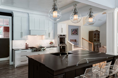 Kitchen pantry - mid-sized eclectic u-shaped porcelain tile kitchen pantry idea in Portland Maine with an undermount sink, recessed-panel cabinets, white cabinets, quartz countertops, white backsplash, porcelain backsplash, paneled appliances and black countertops