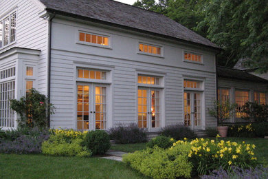 Inspiration for a mid-sized timeless white one-story vinyl gable roof remodel in New York