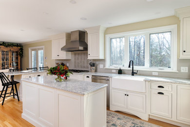 Large transitional u-shaped light wood floor eat-in kitchen photo in Boston with a farmhouse sink, flat-panel cabinets, white cabinets, quartz countertops, green backsplash, ceramic backsplash, stainless steel appliances, an island and multicolored countertops