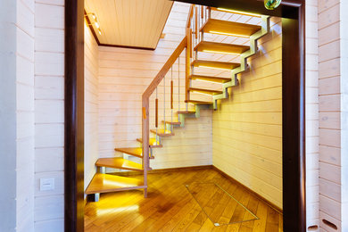 Diseño de escalera en L actual pequeña con escalones de madera y barandilla de madera