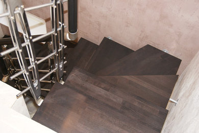На фото: п-образная лестница среднего размера в современном стиле с деревянными ступенями и деревянными перилами