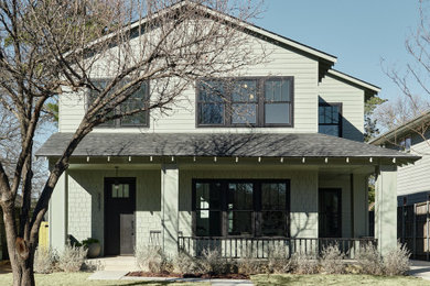 Example of a minimalist green two-story concrete fiberboard and clapboard gable roof design in Dallas with a shingle roof and a black roof