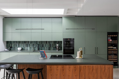 Inspiration for a contemporary open plan kitchen in London with flat-panel cabinets, green cabinets, an island and green worktops.