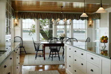 Large traditional l-shaped eat-in kitchen in Boston with white cabinets, with island, a double-bowl sink, flat-panel cabinets, quartzite benchtops, medium hardwood floors and brown floor.