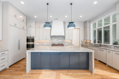 Large trendy u-shaped light wood floor open concept kitchen photo in Dallas with shaker cabinets, marble countertops, stainless steel appliances and an island