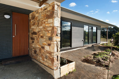 This is an example of a mid-sized contemporary one-storey house exterior in Adelaide with metal siding and a metal roof.