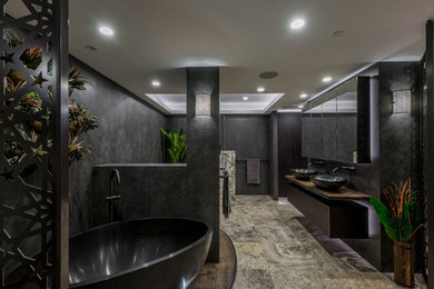 This is an example of a large contemporary master bathroom in Brisbane with furniture-like cabinets, dark wood cabinets, a freestanding tub, a corner shower, a wall-mount toilet, gray tile, porcelain tile, grey walls, travertine floors, a vessel sink, wood benchtops, beige floor, an open shower and brown benchtops.