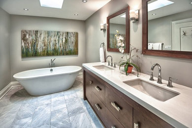 Inspiration for a mid-sized contemporary master stone tile freestanding bathtub remodel in Toronto with flat-panel cabinets, dark wood cabinets, gray walls, an undermount sink and quartzite countertops