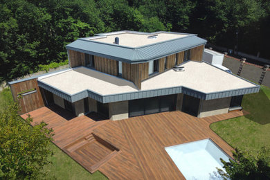 Exemple d'une grande façade de maison moderne en bois à un étage avec un toit plat.