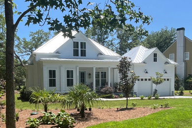 Example of a mid-sized cottage white two-story concrete fiberboard and clapboard house exterior design in Charleston with a hip roof and a metal roof