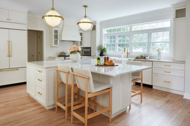 Inspiration for a transitional l-shaped light wood floor and beige floor kitchen remodel in Bridgeport with a farmhouse sink, shaker cabinets, white cabinets, white backsplash, paneled appliances, an island and white countertops