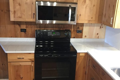 Inspiration for a small rustic u-shaped medium tone wood floor and brown floor enclosed kitchen remodel in Burlington with a double-bowl sink, shaker cabinets, light wood cabinets, quartzite countertops, white backsplash, stone slab backsplash, stainless steel appliances and no island