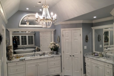 Bathroom - mid-sized traditional master porcelain tile and white floor bathroom idea in New York with raised-panel cabinets, white cabinets, gray walls, an undermount sink, quartzite countertops and a hinged shower door