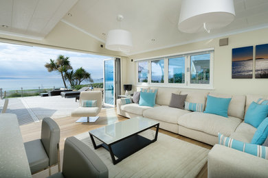 Example of a beach style formal and open concept light wood floor and beige floor living room design in Other with yellow walls