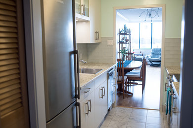 Example of a small transitional galley ceramic tile enclosed kitchen design in Vancouver with a drop-in sink, flat-panel cabinets, gray cabinets, laminate countertops, gray backsplash, glass tile backsplash, stainless steel appliances and no island