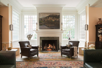 Photo of a mid-sized traditional open concept family room in DC Metro with beige walls, medium hardwood floors, a standard fireplace, a stone fireplace surround and no tv.
