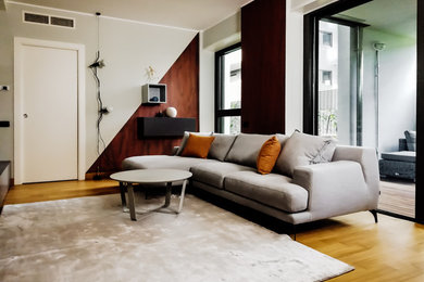 Idee per un soggiorno moderno di medie dimensioni e aperto con pavimento in legno massello medio e TV a parete